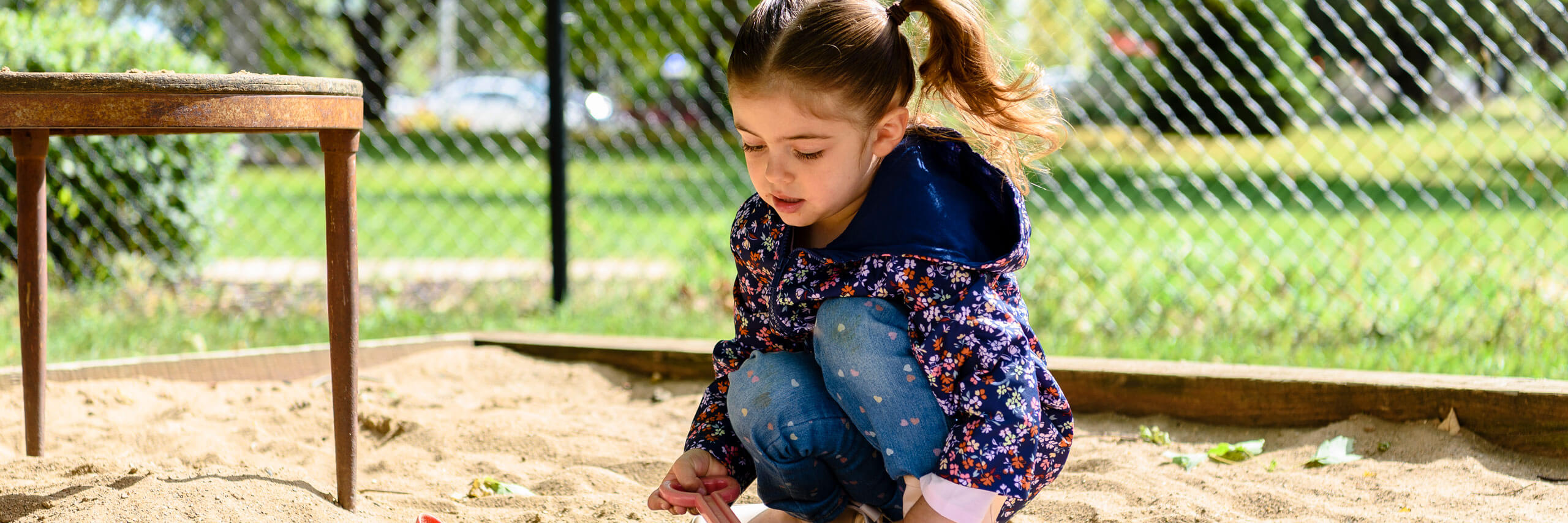 Child plays in a sandbox.
