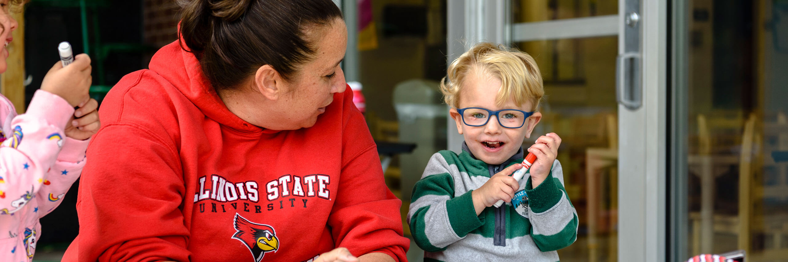 A staff member looks over at a child who is smiling.